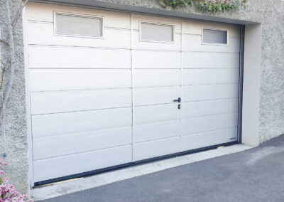 Une porte de garage sur mesure avec portillon et hublot